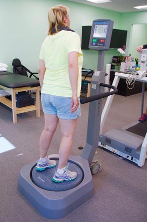 Patient standing on a Biodex balance platform during training
